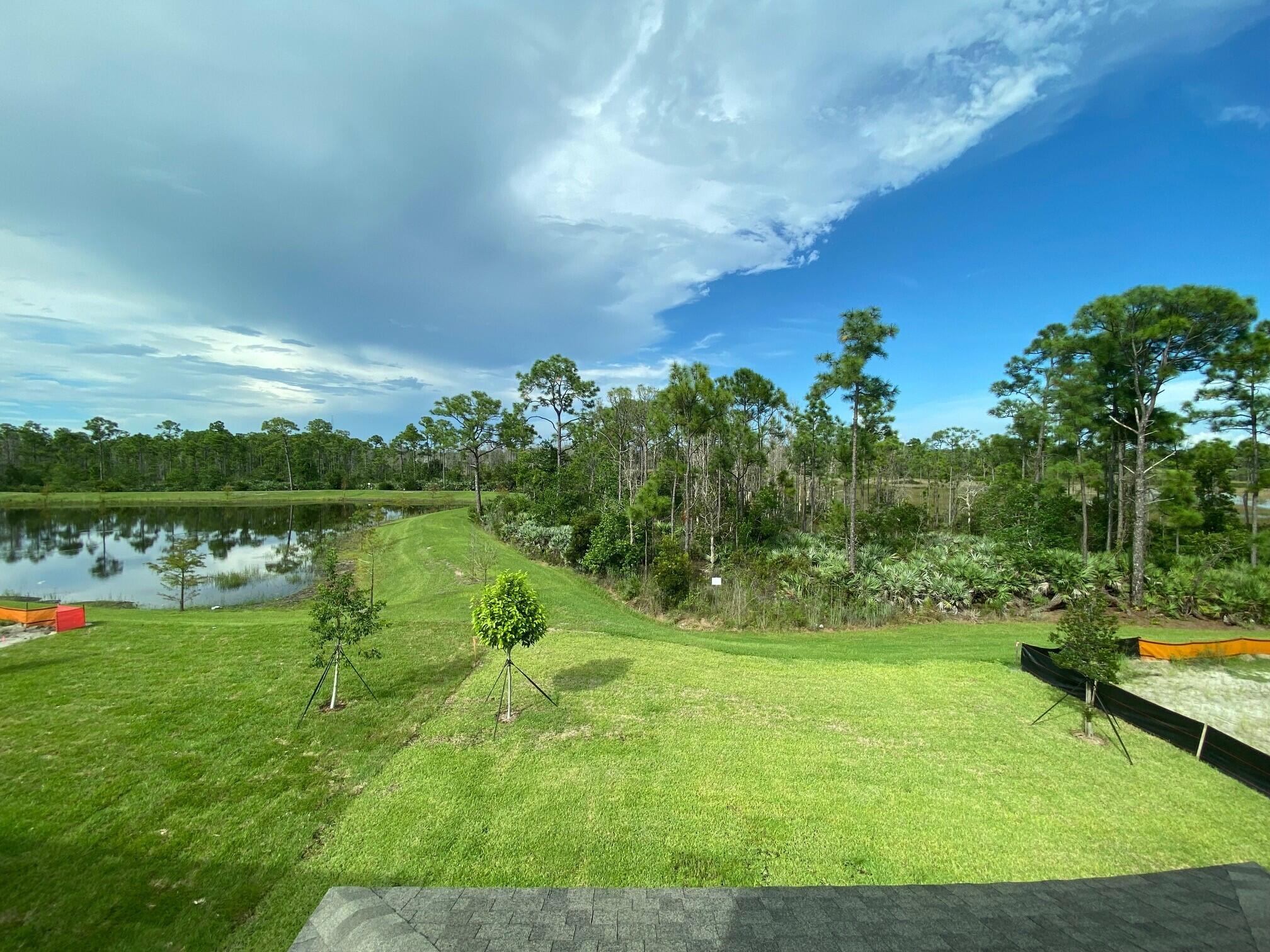 7011 Southeast Park Trace Drive Stuart, FL 34997 - Photo 18 of 19 a view of a lake with a yard