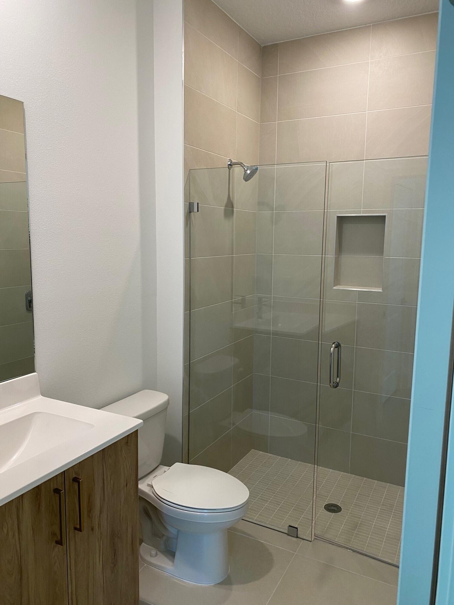 7011 Southeast Park Trace Drive Stuart, FL 34997 - Photo 7 of 19 a bathroom with a shower and toilet