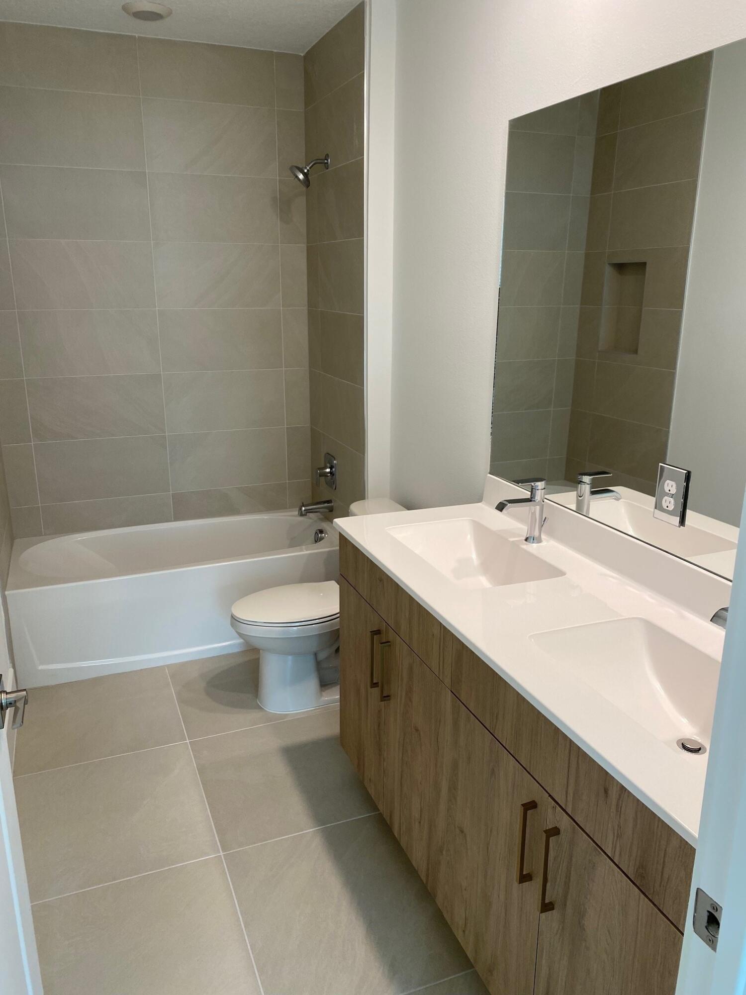 7011 Southeast Park Trace Drive Stuart, FL 34997 - Photo 8 of 19 a bathroom with a sink a toilet and shower