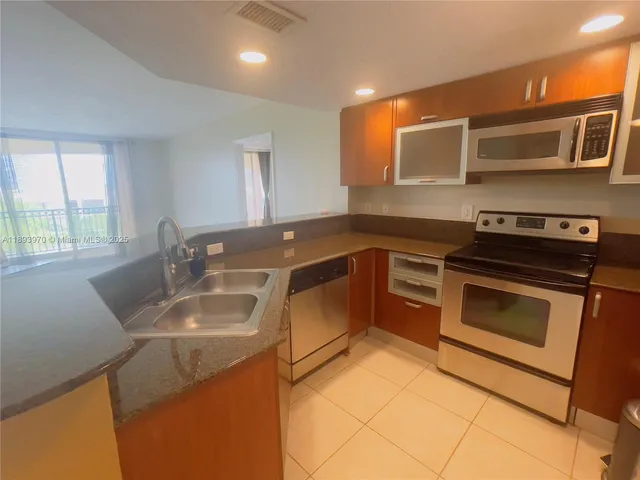 a kitchen with stainless steel appliances granite countertop a sink stove and microwave