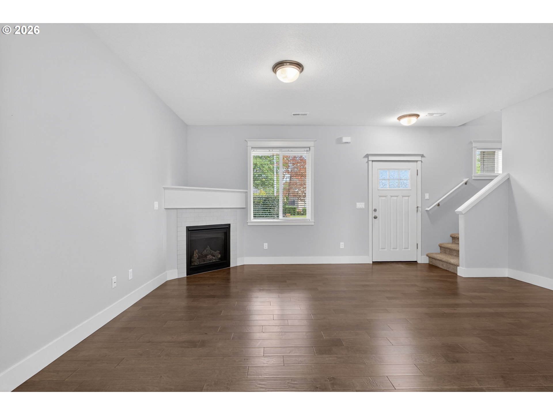 410 Rentfro Way Newberg, OR 97132 - Photo 12 of 39 a view of an empty room with wooden floor fireplace and a window