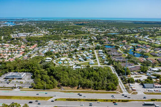 an aerial view of residential houses with outdoor space and trees