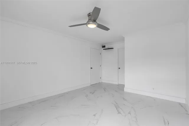 an empty room with a ceiling fan and window
