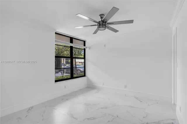 an empty room with windows and fan