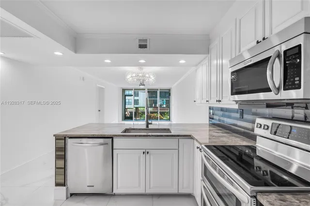 a kitchen with stainless steel appliances granite countertop a sink and a stove
