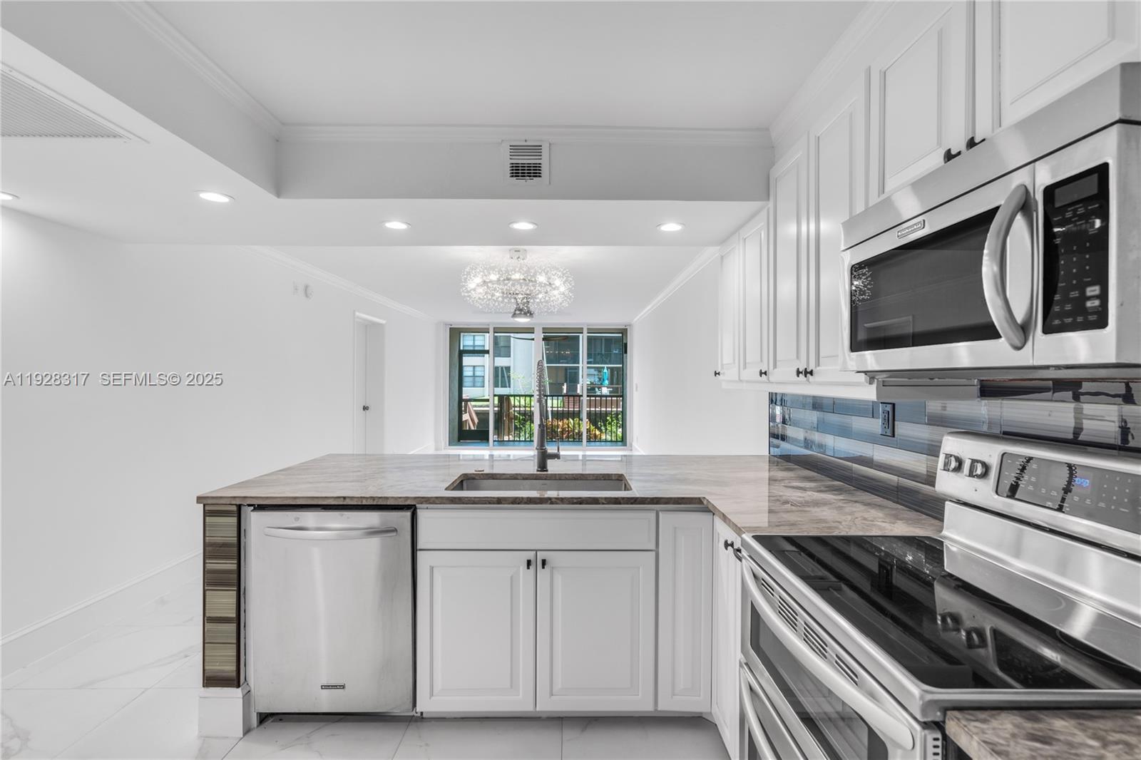 12 Royal Palm Way, Unit 103 Boca Raton, FL 33432 - Photo 4 of 29 a kitchen with stainless steel appliances granite countertop a sink and a stove