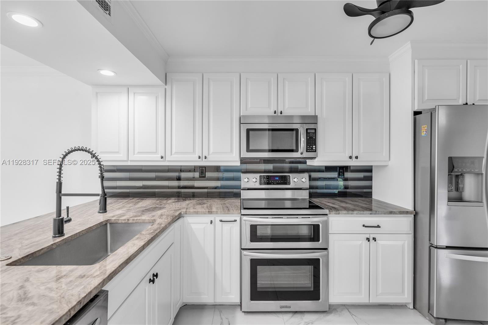 12 Royal Palm Way, Unit 103 Boca Raton, FL 33432 - Photo 5 of 29 a kitchen with white cabinets and stainless steel appliances