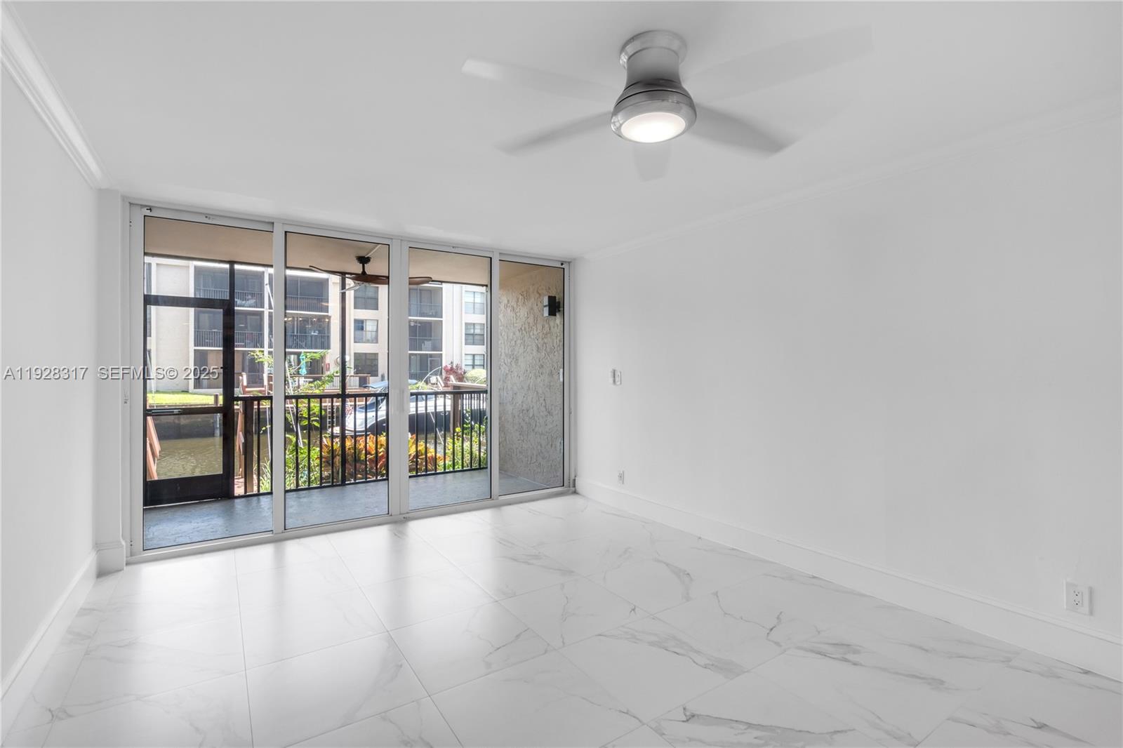 12 Royal Palm Way, Unit 103 Boca Raton, FL 33432 - Photo 7 of 29 an empty room with floor to ceiling windows and chandelier