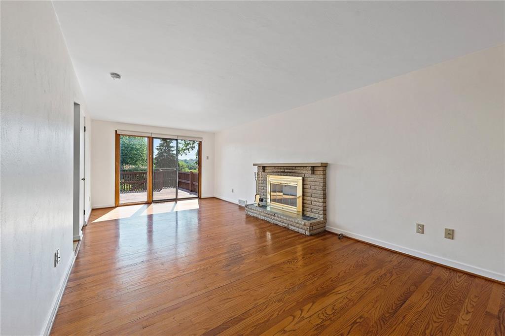 335 Twin Oaks Road Pittsburgh, PA 15243 - Photo 3 of 24 The large living room boasts original hardwoods, a gas fireplace, and access to the deck outside.