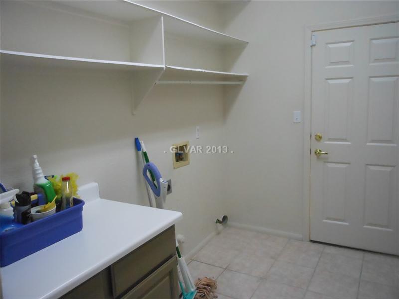 4716 Monument Valley Road Las Vegas, NV 89129 - Photo 23 of 31 Property Photo. Large laundry area with shelves and cabinet space.