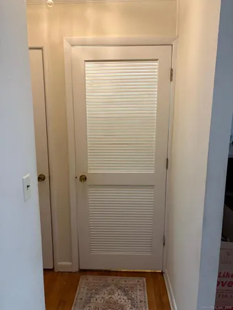 a view of hallway with closet and wooden floor