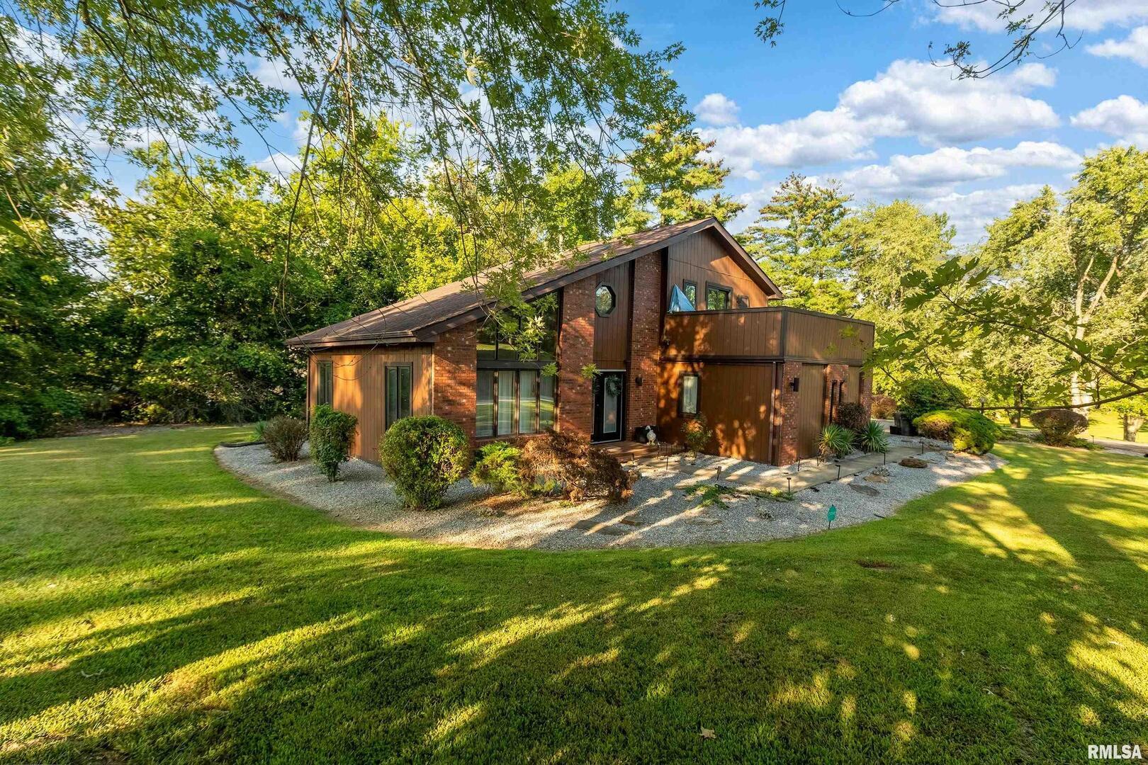 a view of a house with yard and sitting area