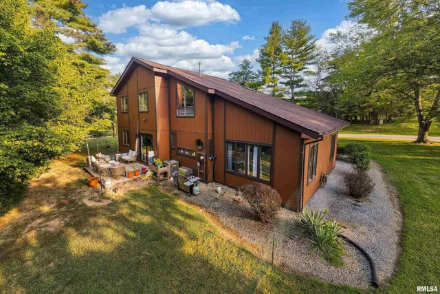 a aerial view of a house with table and chairs under an umbrella