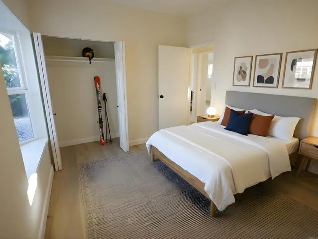 a bedroom with a bed and painting on the wall