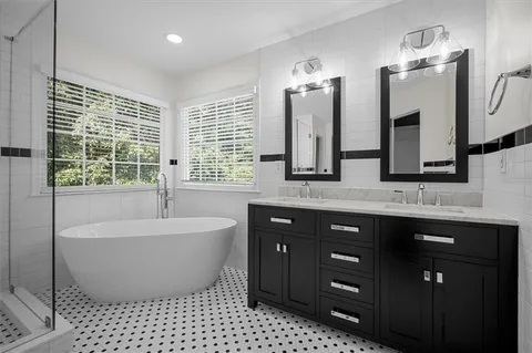 a spacious bathroom with a bathtub sink and mirror