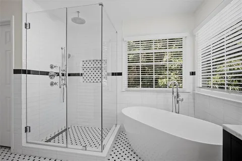 a bathroom with a bathtub a window and a shower