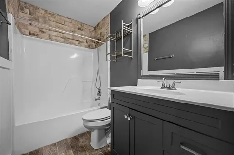 a bathroom with a granite countertop sink toilet and shower