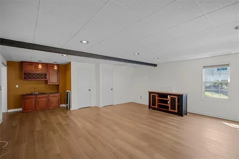 a view of empty room with a kitchen and wooden floor