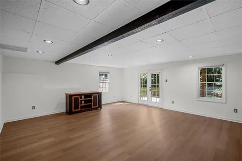 a view of a big room with wooden floor and windows