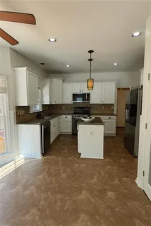 a kitchen with stainless steel appliances granite countertop a stove top oven a refrigerator a sink and dishwasher