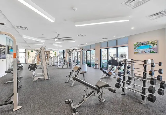 a living room with furniture a potted plant and open kitchen view