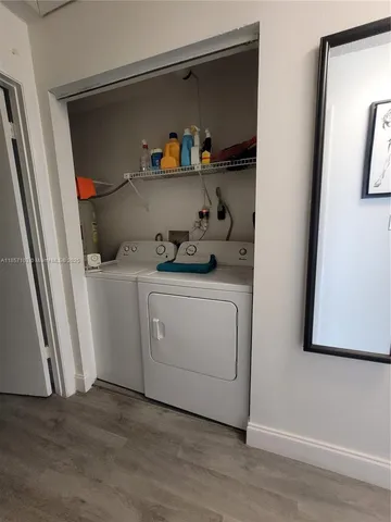a utility room with wooden floor washer and dryer