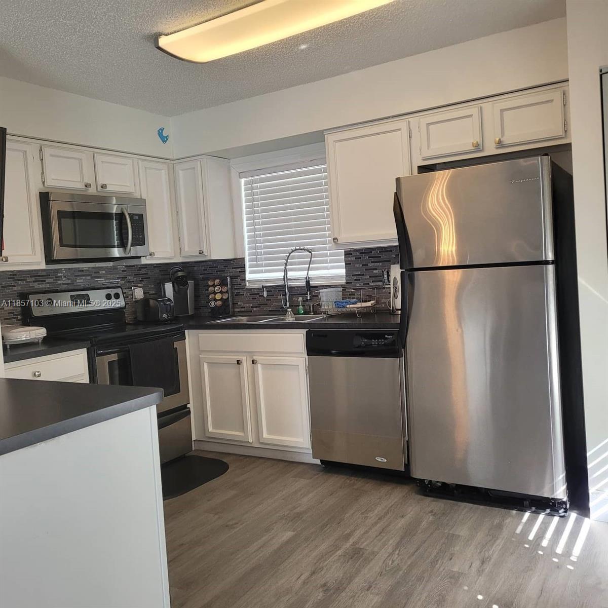 4375 White Pine Avenue, Unit 824 Orlando, FL 32811 - Photo 4 of 12 a kitchen with a refrigerator sink and microwave
