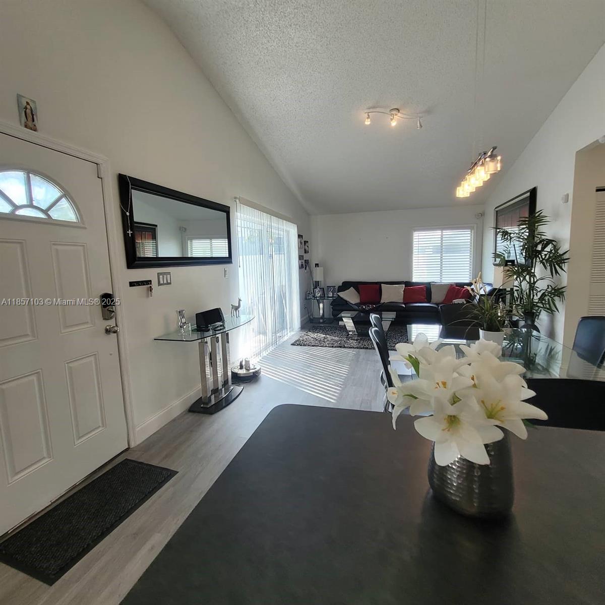 4375 White Pine Avenue, Unit 824 Orlando, FL 32811 - Photo 6 of 12 a room with lots of white furniture a chandelier and a window