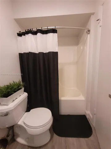 a bathroom with a toilet and a shower curtain