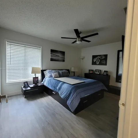 a spacious bedroom with a bed a couch and a large window