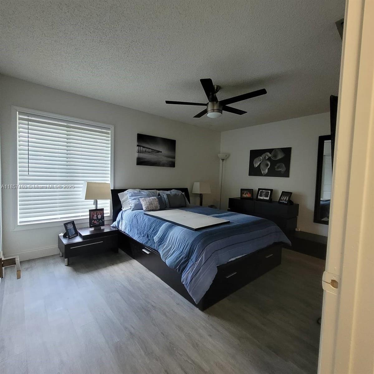 4375 White Pine Avenue, Unit 824 Orlando, FL 32811 - Photo 10 of 12 a spacious bedroom with a bed a couch and a large window