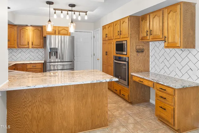 a kitchen with stainless steel appliances granite countertop a sink refrigerator and cabinets