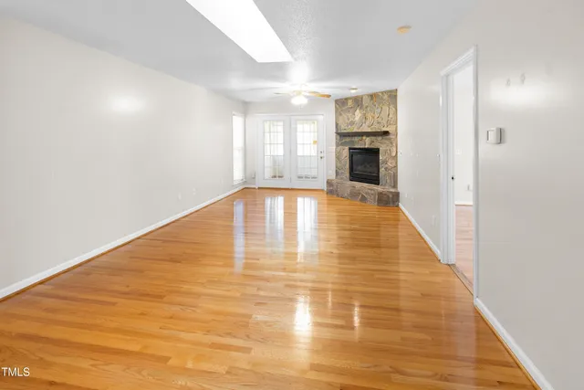 a view of empty room with wooden floor and fireplace
