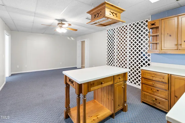 a utility room with a sink a cabinets and wooden floor