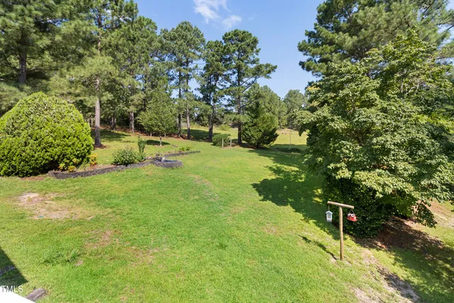 a backyard of a house with lots of green space and trees all around