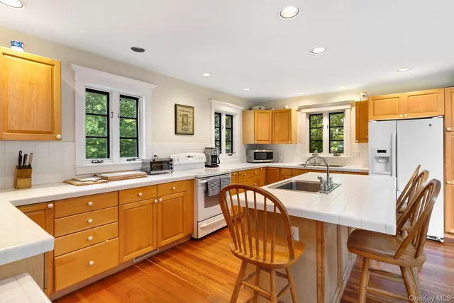 a kitchen with stainless steel appliances granite countertop a table chairs sink refrigerator and cabinets