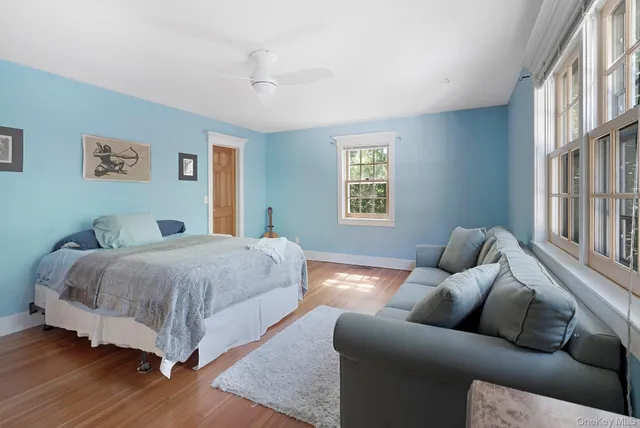 a spacious bedroom with a bed couch and a window
