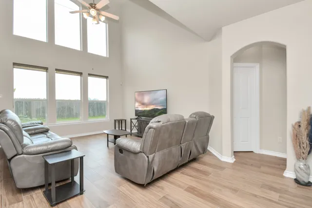 a living room with furniture and a floor to ceiling window