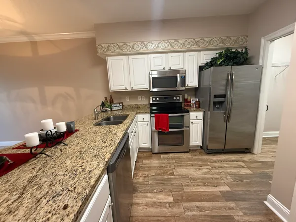 a kitchen with stainless steel appliances kitchen island granite countertop a refrigerator stove and microwave