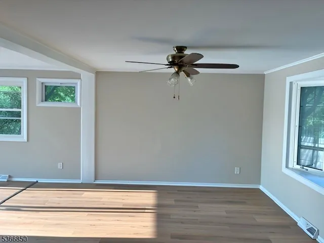 a view of a livingroom with a ceiling fan and window