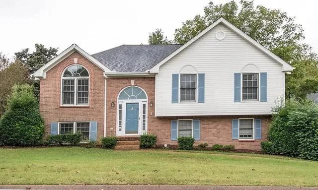 a front view of a house with a yard and trees
