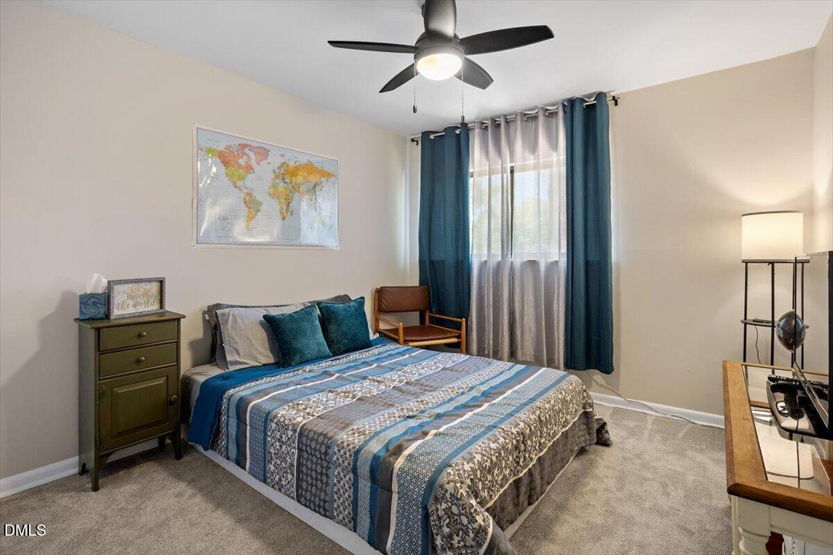 5045 Tall Pines Court Raleigh, NC 27609 - Photo 27 of 37 a bedroom with a bed and a chandelier