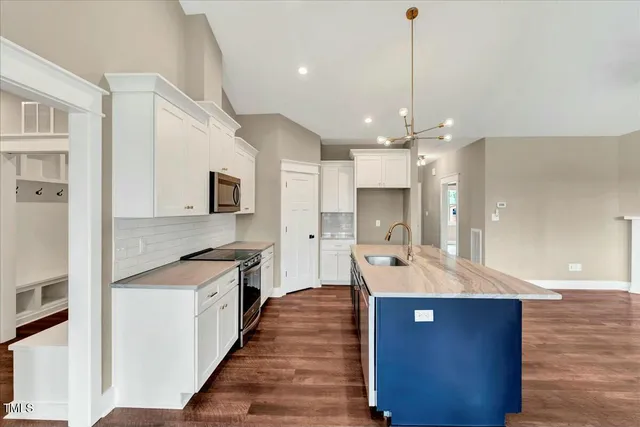 a view of an empty room with wooden floor and a fireplace