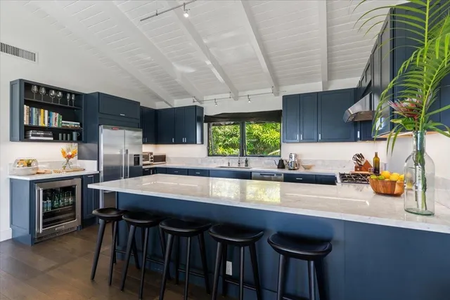 a kitchen with stainless steel appliances a table chairs sink and cabinets