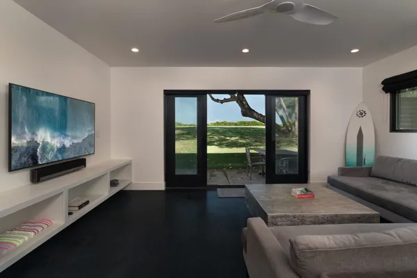 a living room with furniture tv and a floor to ceiling window
