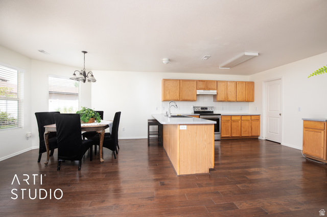 342 South Willow Patch Road Lehi, UT 84043 - Photo 13 of 30 Wood-finish flooring throughout, light wood cabinetry, kitchen island with sink, stainless steel range, and tile backsplash