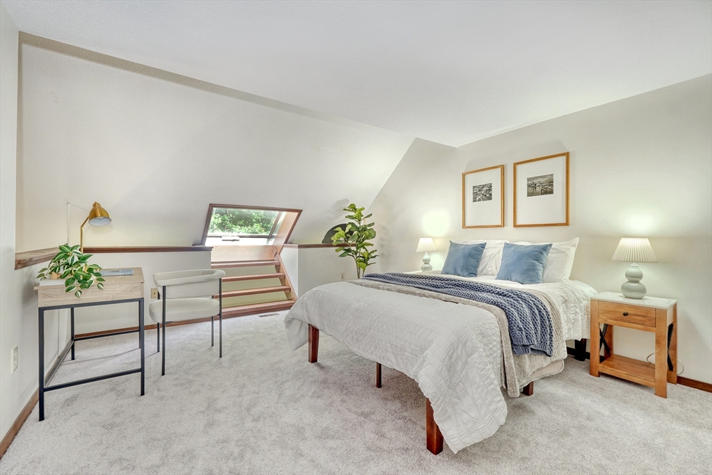 422 Great Elm Way, Unit 422 Acton, MA 01718 - Photo 16 of 30 a bed room with a bed and a lamp