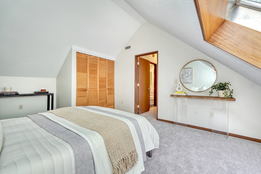 422 Great Elm Way, Unit 422 Acton, MA 01718 - Photo 19 of 30 a bedroom with a bed a mirror and a window