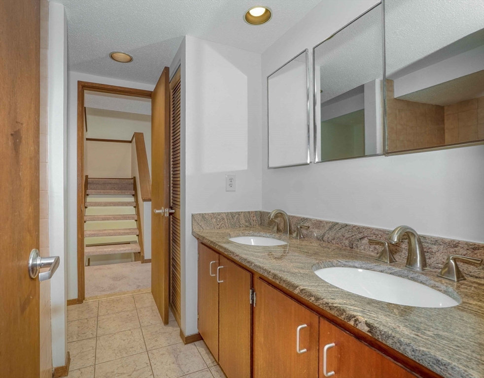 422 Great Elm Way, Unit 422 Acton, MA 01718 - Photo 25 of 30 a bathroom with a granite countertop sink and a mirror