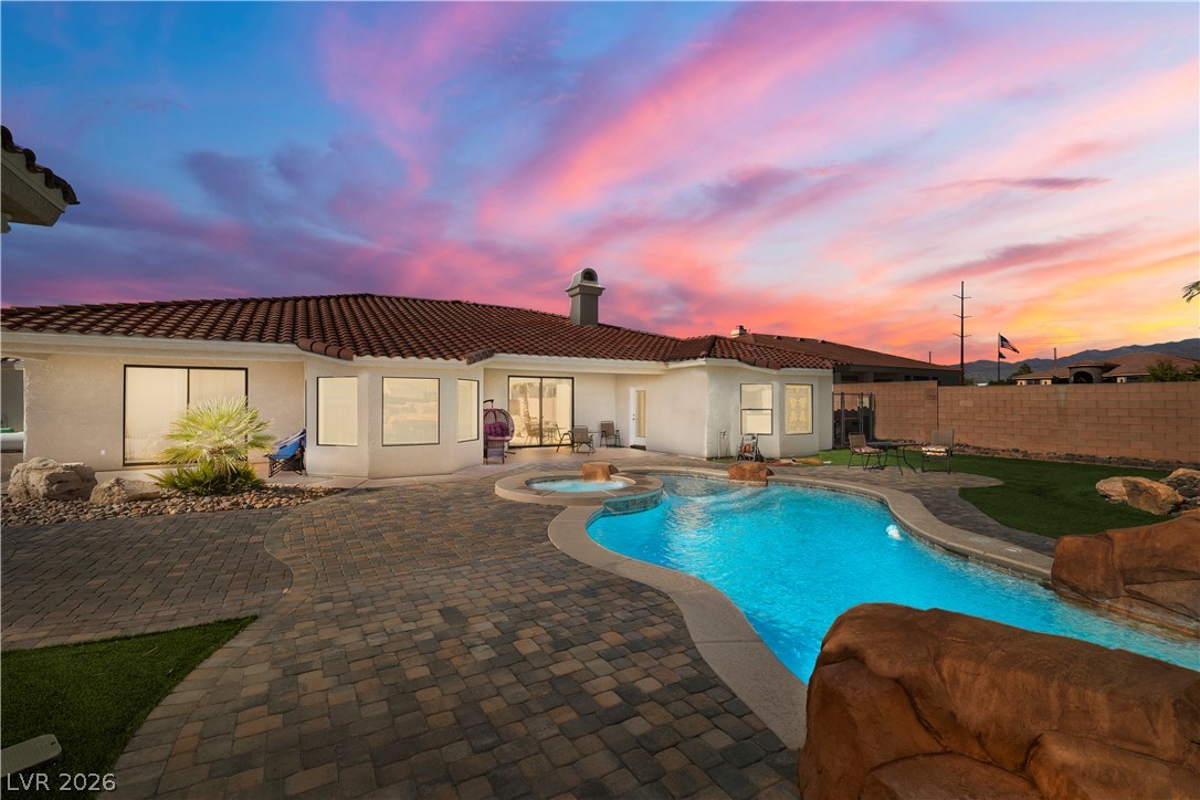 2181 Winery Road Pahrump, NV 89048 - Photo 4 of 52 A custom pool and spa beckon under a vivid sunset, creating a private outdoor oasis.